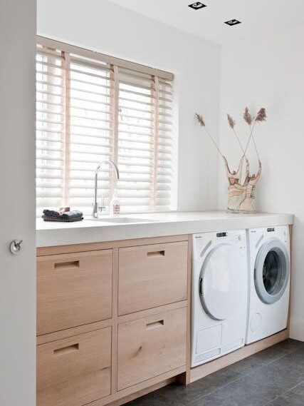 Laundry countertop over washer and dryer with deck-mounted faucet